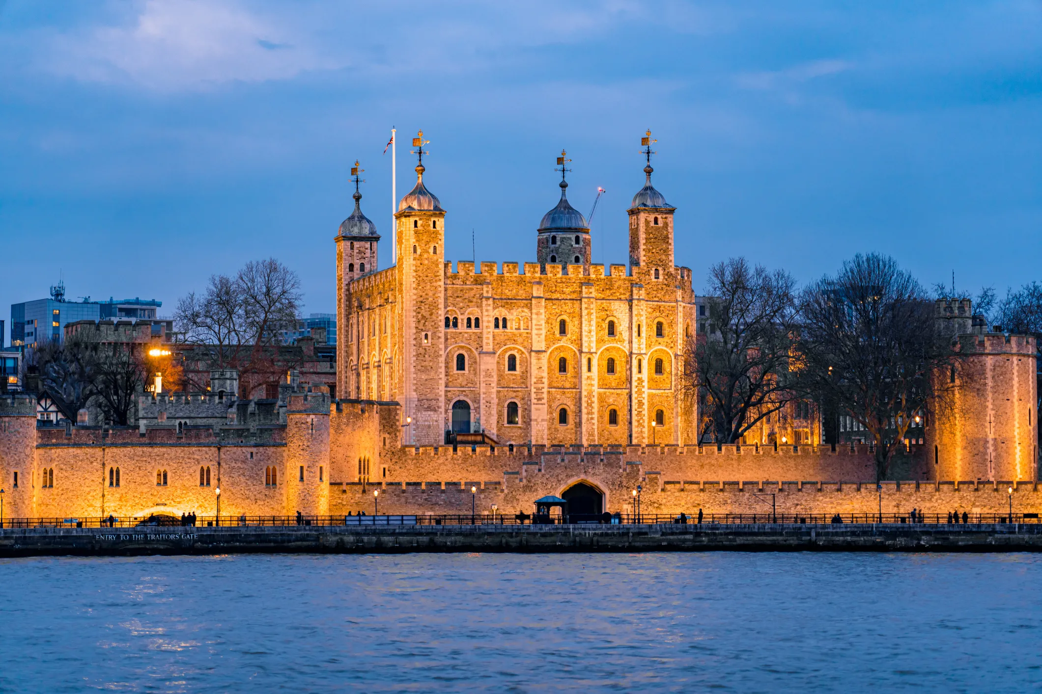 Tower of London illuminated at night along the Thames